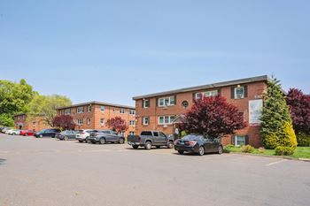 A parking lot with cars in front of an apartment building